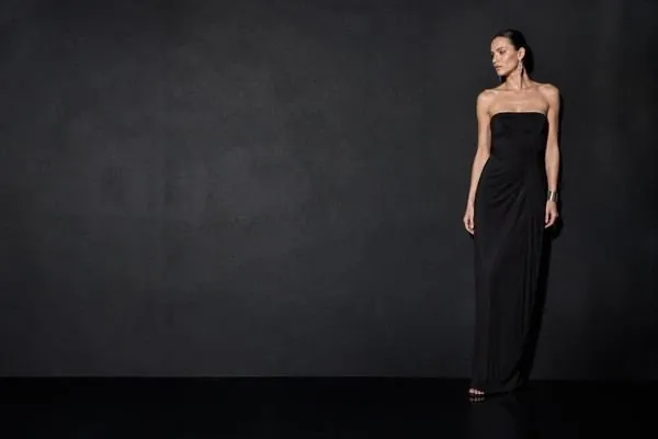 Model in a black evening gown with floor reflection