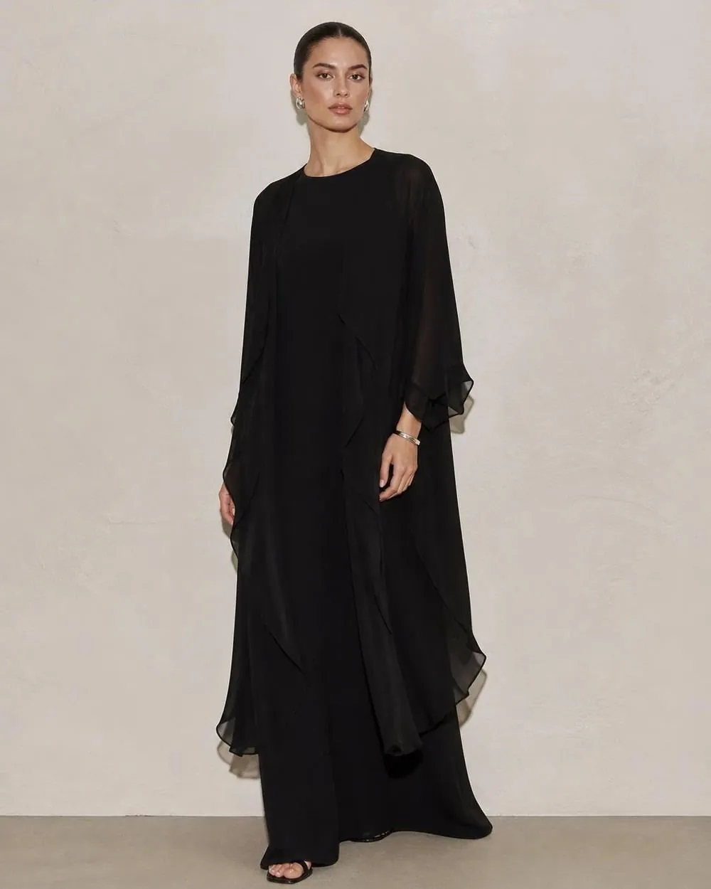 Model in layered sheer black dress fabrics